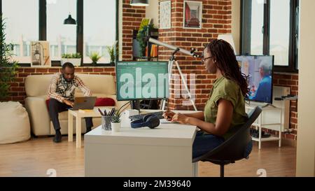Businesswoman analyzing diagrams report and taking notes, writing financial sales information after looking at statistics on computer. Employee doing accounting job remotely at home. Stock Photo