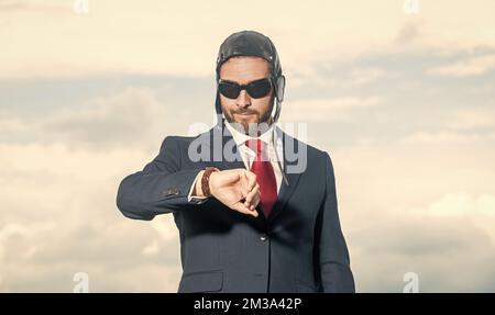 businessman in suit and pilot hat checking time Stock Photo