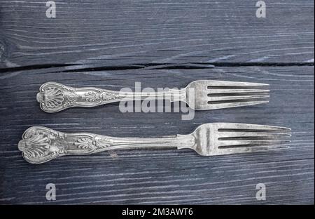 Vintage silverware on rustic wooden background. Rustic vintage set of cutlery forks. Black background. Top view Stock Photo