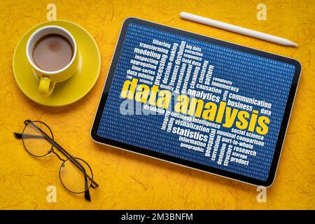 data analysis word cloud on a digital tablet, flat lay with coffee, information and technology concept Stock Photo