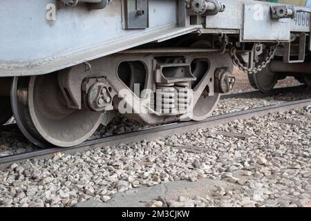 Closed Up to Cargo Train Car Undercarriage in Railroad with Stones Stock Photo