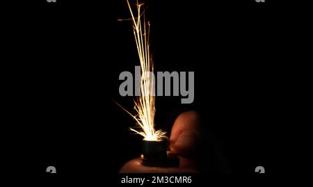 Closeup to hand igniting fire lighters with black background. Energy and light concept Stock Photo