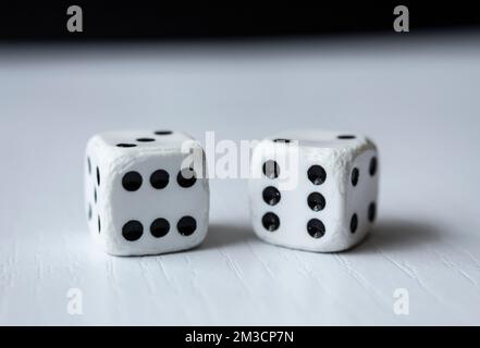 Macro photograhpy to an Old white dices with double six pair over a white table and black background Stock Photo