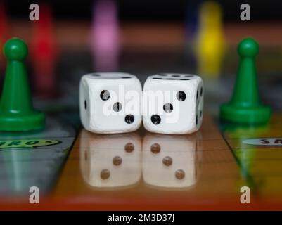 Macro photograhpy to an Old white dices with double three pair and color pawns over a board game Stock Photo