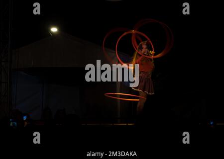 woman dancing with many hoops, at night with lights in mexico Stock Photo