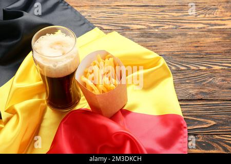 Belgium flag, glass of beer and paper box with french fries on wooden background Stock Photo