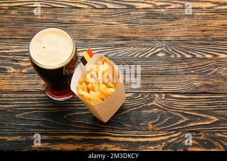 Glass of Belgium beer and french fries on wooden background Stock Photo