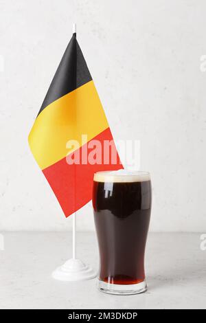 Belgian flag and glass of beer on light background Stock Photo