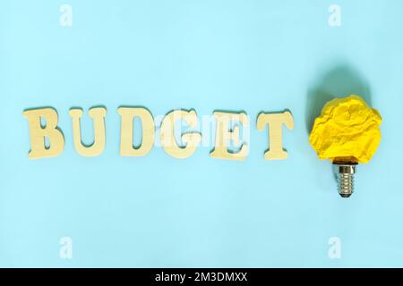 How to budget and budgeting ideas and tips concept. Bright yellow crumpled paper light bulb. Stock Photo