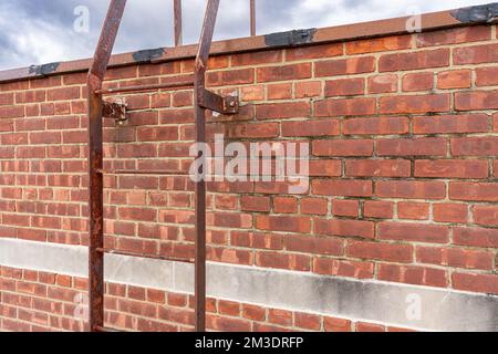 Old industrial, commercial brick building with metal roof access ladder. Stock Photo