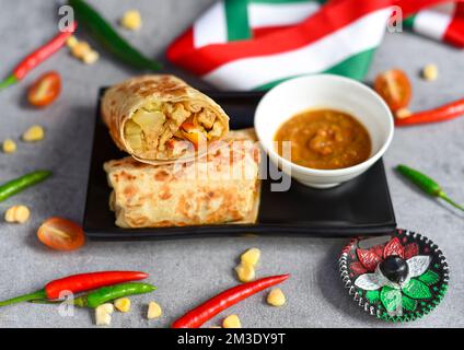 Vegetarian Mexican burrito with potato, tofu,rice served with sauce brracha Stock Photo