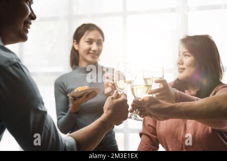 Group of happy colleagues having fun at a new year celebration or business success. Coworkers with diverse people at the office party Stock Photo