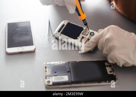 The technician repairing the smartphone's motherboard in the lab with copy space. the concept of computer hardware, mobile phone, electronic Stock Photo