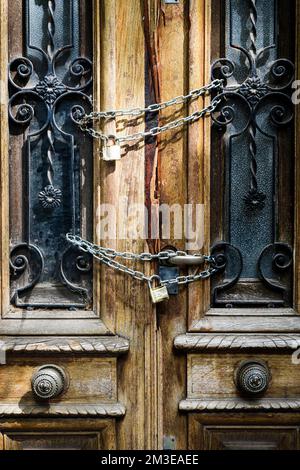 Old wooden door of an abandoned house is locked. Chain on the vintage door of a closed mansion. High quality photo Stock Photo