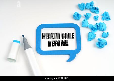 Medicine and health. On a white surface are crumpled blue paper, a marker and a sign inside which is written - HEALTH CARE REFORM Stock Photo