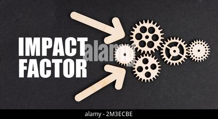 Business and finance concept. On the black surface, arrows, gears and an inscription - IMPACT FACTOR Stock Photo