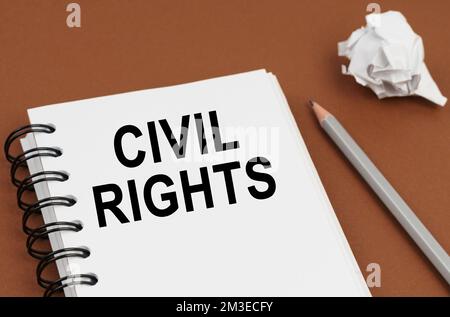 Business and finance concept. On a brown surface lies a pen, crumpled paper and a notepad with the inscription - CIVIL RIGHTS Stock Photo