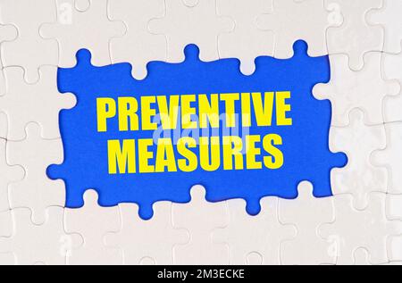 Medicine and health concept. Inside the white puzzles on a blue background it is written - preventive measures Stock Photo