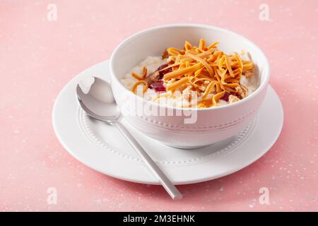 rice pudding with Norwegian brunost traditional brown cheese and raspberry jam Stock Photo