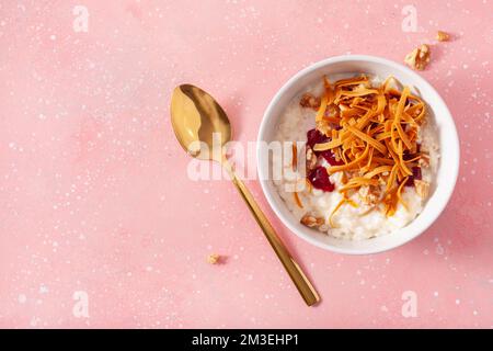 rice pudding with Norwegian brunost traditional brown cheese and raspberry jam Stock Photo