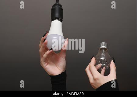 Installing new led light bulb in table lamp Stock Photo - Alamy