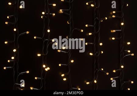 Christmas cluster micro LED warm light strings, fairy light festive decoration against dark background Stock Photo