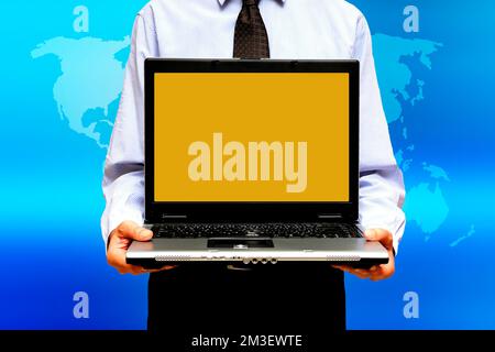 businessman holding a laptop with a blank screen over a world map, global business concept Stock Photo