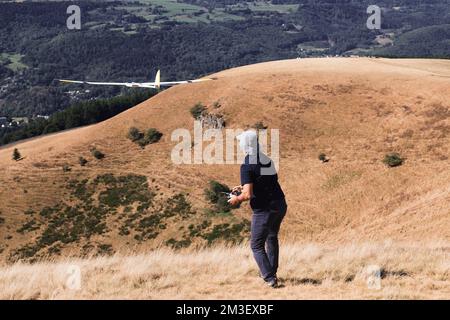 A closeup of a man launches a radio-controlled model glider during an aircraft modeling competition Stock Photo
