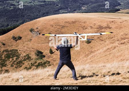 A closeup of a man launches a radio-controlled model glider during an aircraft modeling competition Stock Photo