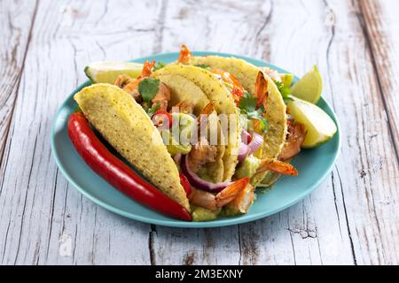 Mexican tacos with shrimp,guacamole and vegetables on wooden table Stock Photo