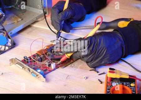 checking video card from desktop computer with ammeter on table Stock Photo