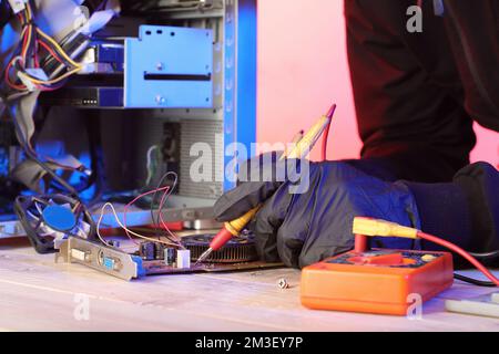 checking video card from desktop computer with ammeter on table Stock Photo