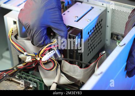disconnecting the power from the hard drive of the old computer on the table Stock Photo