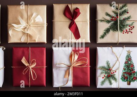 a group of wrapped presents with a christmas tree on them and a red ribbon tied around them with a bow. . Stock Photo