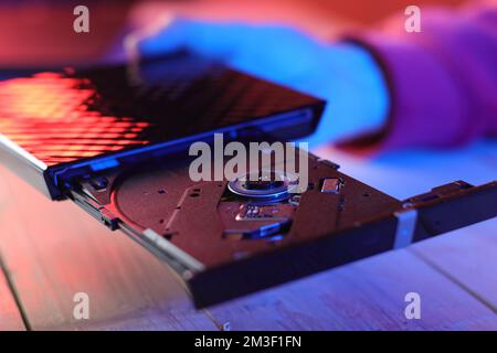 laptop optical drive with open tray on table and colored background Stock Photo