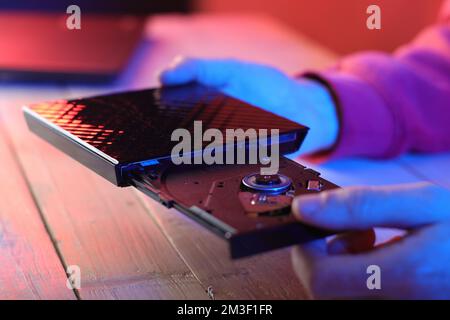 laptop optical drive with open tray on table and colored background Stock Photo