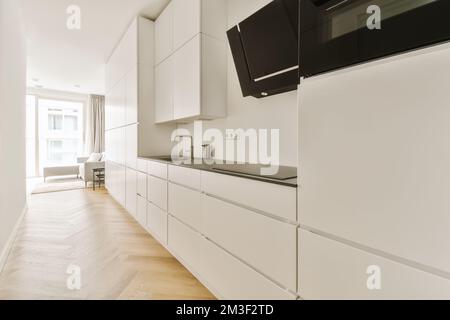 a kitchen with white cupboards and black appliances on the counter tops in this room is very clean, but it's not Stock Photo