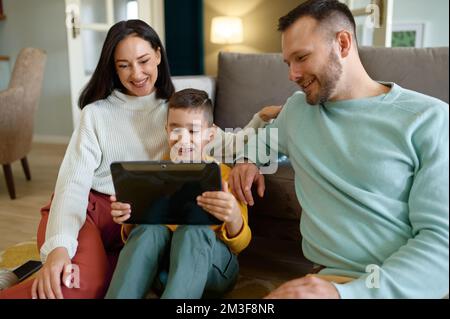 Happy family using mobile tablet at home together Stock Photo