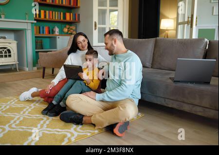 Happy family using mobile tablet at home together Stock Photo