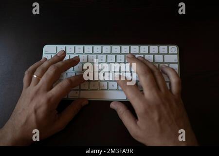 Hands typing on computer keyboard. man hands on the keyboard Working at home Stock Photo
