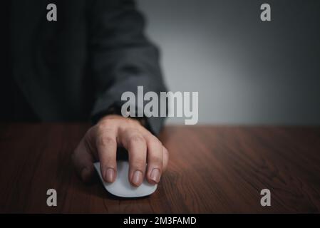Hand using computer mouse, clicking pointer laptop on desk. Stock Photo