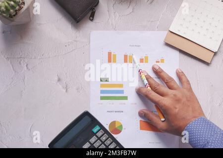 man hand with pen analyzing bar chart on paper  Stock Photo