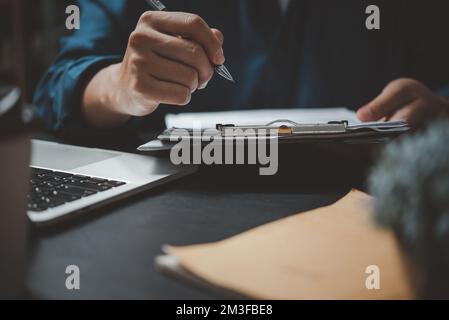 Business man reading agreement paper before sign document with use pen at work. Stock Photo