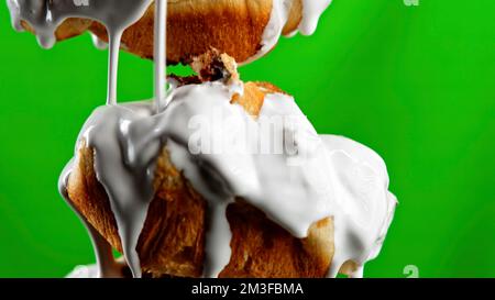 Lush sweet buns on a green and pink background. Stock clip.Sweet donuts that are poured with white sugar cream and filmed in close-up. High quality 4k Stock Photo