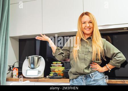 White kitchen machine and stand mixer on a wooden table in a bright design  apartment Stock Photo - Alamy