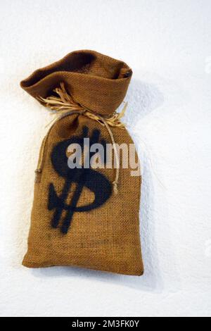 full bank bag with US dollar sign on a white wall Stock Photo