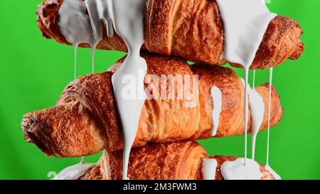 Concept of delicious breakfast. Stock clip. White glaze draining down the freshly baked croissants, close up view Stock Photo
