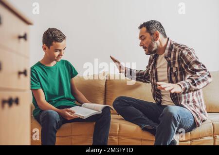 Father is helping his son with learning. Boy is having problem with homework. Stock Photo
