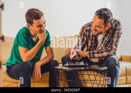Father and son are playing chess at home. Stock Photo