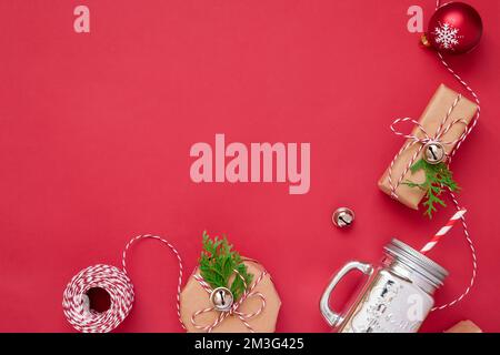 Christmas background with gift boxes, rope, paper's rools and decorations on red. Preparation for holidays.  Stock Photo